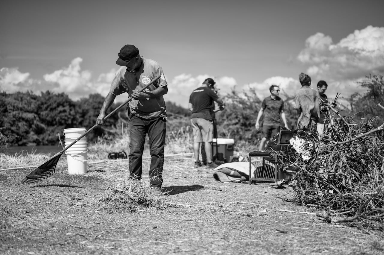 A group of volunteers engaging in environmental cleanup near a river.